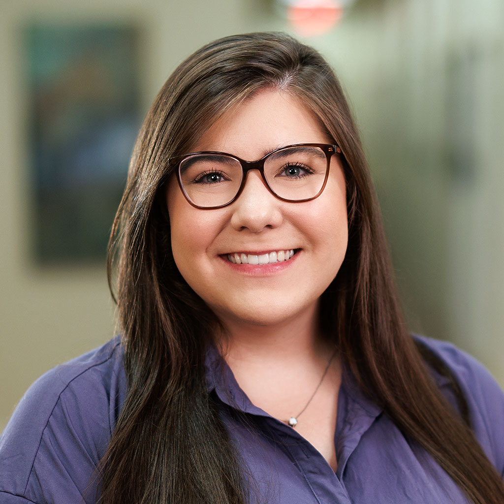 Headshot of Abby Davis in glasses and purple shirt